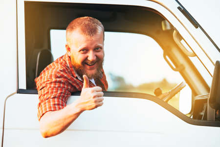 Bearded driver sits in the car and shows that everything is fineの写真素材