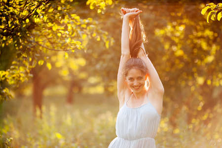 Beautiful happy young woman in summer in the gardenの写真素材