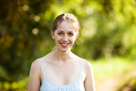 Portrait of a beautiful young smiling woman in a blue dressの写真素材