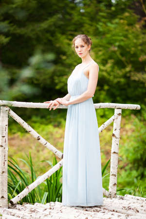 Slender young woman in a long blue dressの写真素材