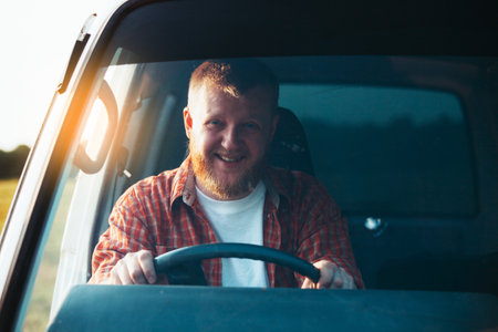Smiling bearded driver driving his old carの写真素材