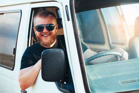 Cheerful driver in sunglasses driving a carの写真素材