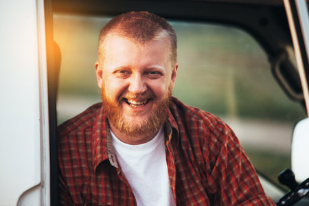 Smiling bearded driver sitting in the cockpit of his carの写真素材