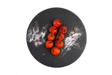 Baked cherry tomatoes on a branch on a white backgroundの写真素材