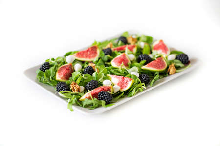 Figs, blackberries, arugula, mozzarella and walnuts salad. Shot with shallow depth of field.の写真素材