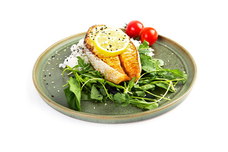 Baked salmon steak with rice and tomatoes on a plateの写真素材