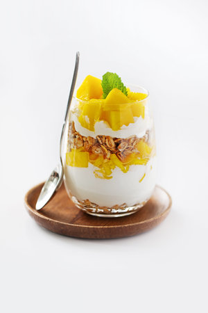 Glass with yogurt and pineapple dessert on a wooden plateの写真素材