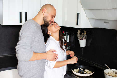Young husband and wife are cooking in the kitchen at homeの写真素材