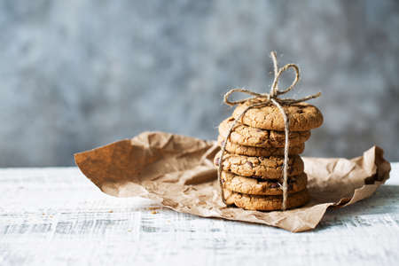 Stack of delicious cookies tied with twine lies on paper on the tableの写真素材