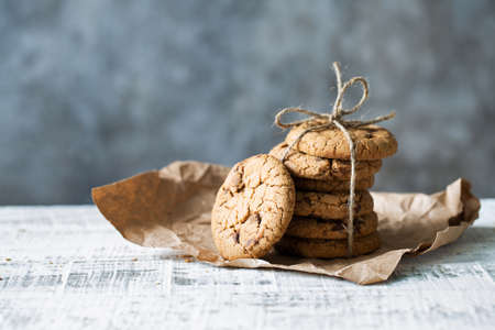 Stack of oatmeal cookies with chocolate lies on a white tableの写真素材