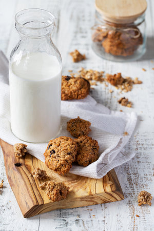 Fresh oatmeal cookies and a bottle of milk on the tableの写真素材