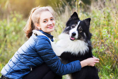 Cute girl sitting next to her beloved dogの写真素材