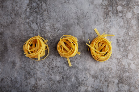 Three balls of long Italian spaghetti on a gray backgroundの写真素材