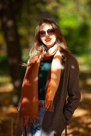 Beautiful young woman in sunglasses in the rays of the autumn sunの写真素材