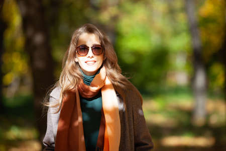 Beautiful young woman in sunglasses in autumn forestの写真素材