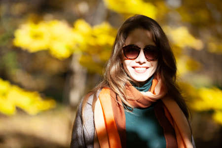 Young pretty woman in sunglasses in the rays of the autumn sunの写真素材