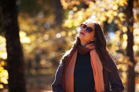 Young woman in sunglasses in the park in sunny weatherの写真素材
