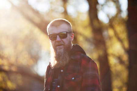 Blonde bearded man in sunglasses on a sunny autumn eveningの写真素材
