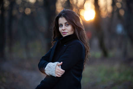 Portrait of a young beautiful woman in the evening autumn forestの写真素材
