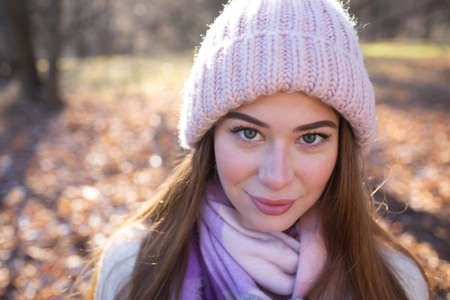 Portrait of a beautiful young woman in a knitted pink hatの写真素材