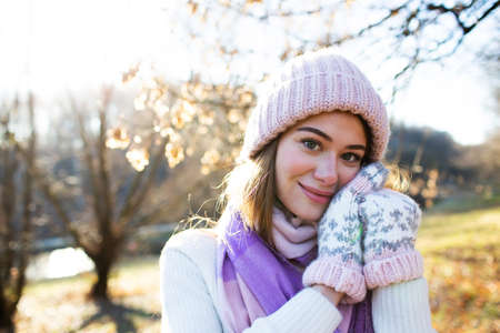 Portrait of a beautiful pretty girl in a knitted hat and mittensの写真素材