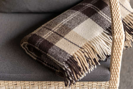 The texture of the fabric of a warm woolen brown beige checkered plaid with fringes. Blurred background, shallow depth of field.の素材 [FY310153834312]