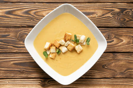 Vegan pumpkin cream soup with croutons in a white ceramic plateの写真素材