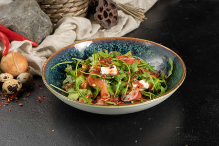 Salad with salmon, radish, arugula, cucumber, parsley and feta cheese seasoned with red pepper sauce.の写真素材