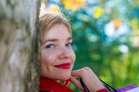 woman looking behind treeの写真素材