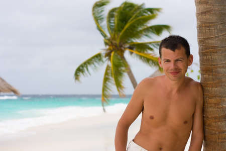 Young man on a tropical beach in the morning during a galeの写真素材