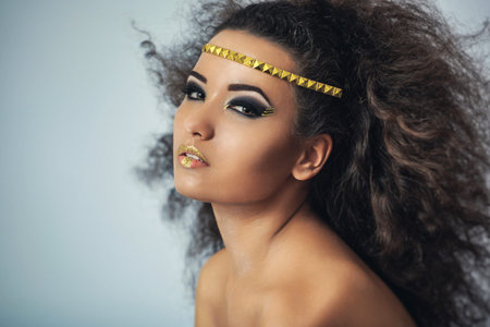 Mulatto girl with curly hair. Portrait in the studio.の写真素材