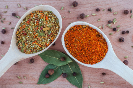 spices for meat dishes in a wooden spoon on the wood, chopping board