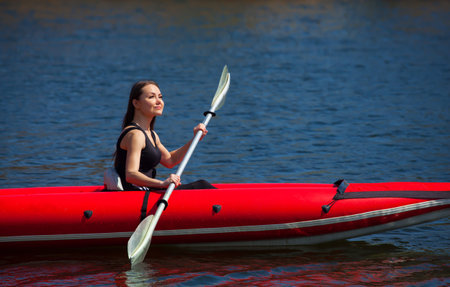 The girl athlete swimming, kayaking on the lake.