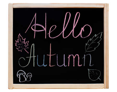 The inscription "Hello Autumn" written on a blackboard in a wooden frame, colorful chalk. On the sides painted leaves of trees and mushrooms.の写真素材