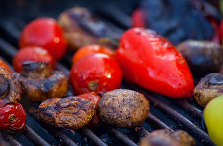 Red, yellow bell peppers, potatoes, mushrooms, tomatoes and eggplant grilled until golden brown. The concept of proper nutrition and a healthy lifestyle. Cooking vegetables on the barbecue.の写真素材