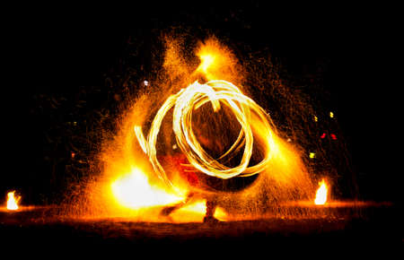 Man entertains the audience with the help of fire, carrying fire performance night.の写真素材