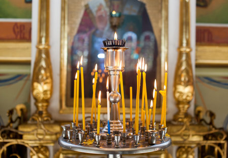 Church candles standing in the temple on the stand during the service. Religious Orthodoxy and Catholicism symbol.の写真素材