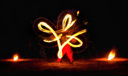 Man entertains the audience with the help of fire carrying fire performance night.の写真素材