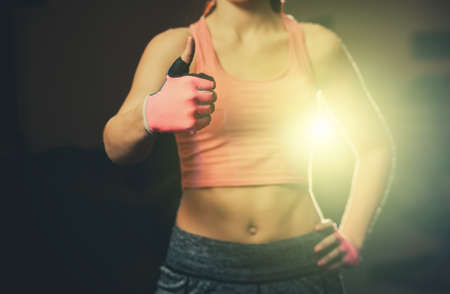The hand of an athletic, beautiful woman shows a thumb up, like, good, approval. thumb up hand sign approval of sports.の写真素材