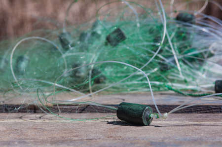 The fishing net lies on a wooden pier on the river bank.の写真素材