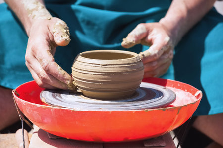 The man - Potter from the clay pitcher on a Potter's wheel.