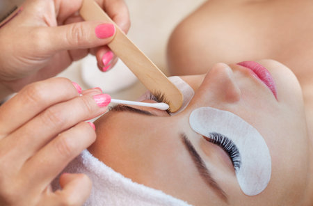 Eyelash removal procedure close up. Beautiful Woman with long lashes in a beauty salon. Eyelash...