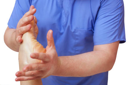 The doctor-podiatrist does an examination and massage of the patient's foot in the clinic.の写真素材