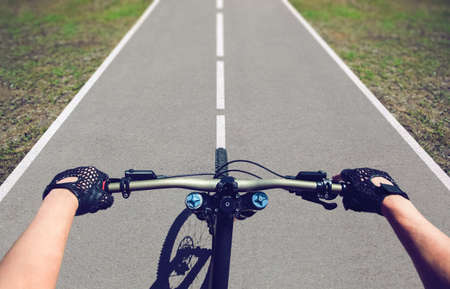 One young man-sportsman rides a mountain bike on an asphalt road.の写真素材
