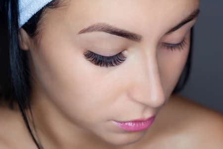 Eyelash removal procedure close up. Beautiful Woman with long lashes in a beauty salon. Eyelash extension.の写真素材