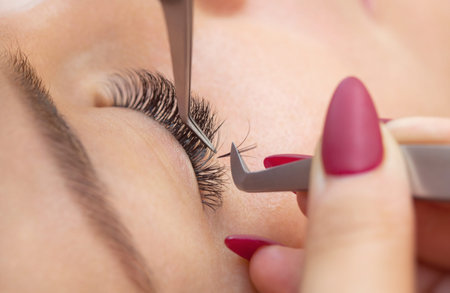 Eyelash removal procedure close up. Beautiful Woman with long lashes in a beauty salon. Eyelash...