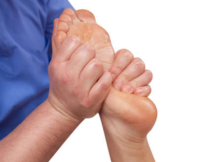 The doctor-podiatrist does an examination and massage of the patient's foot in the clinic.の写真素材