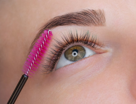 Beautiful Woman with long eyelashes in a beauty salon. Eyelash extension procedure. Lashes close up