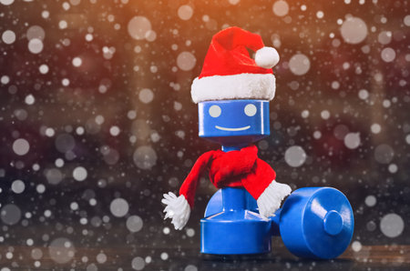 Plastic dumbbell with a red cap of Santa Claus in the gym, close-up against the background of snowflakes. Sports and New Year concept, fat burning and healthy lifestyle.の写真素材