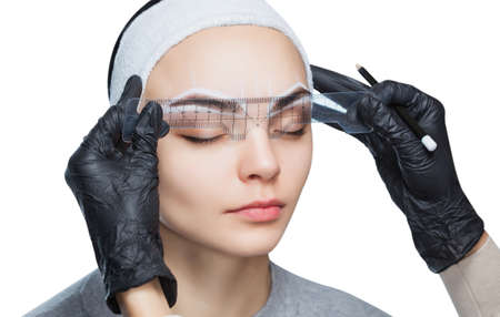 Permanent make-up for eyebrows of beautiful woman with thick brows in beauty salon.の写真素材
